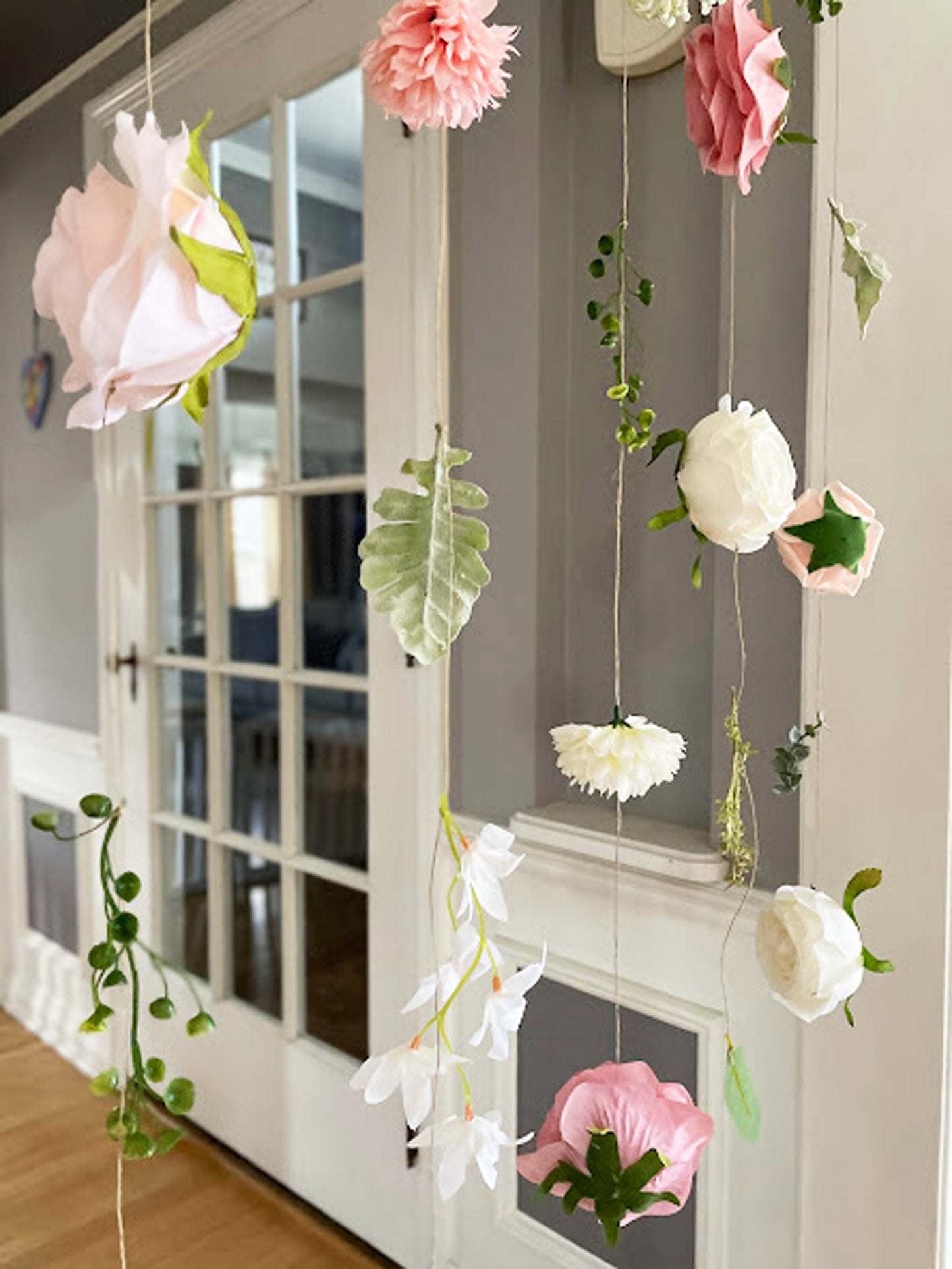 Decorative hanging flowers in front of a glass door