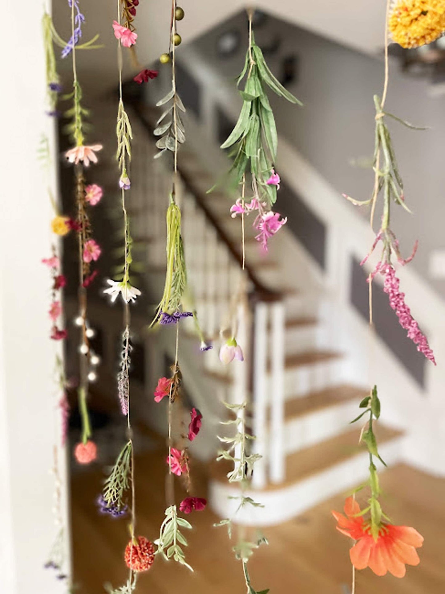 Decorative hanging plants with colorful flowers in a home setting.