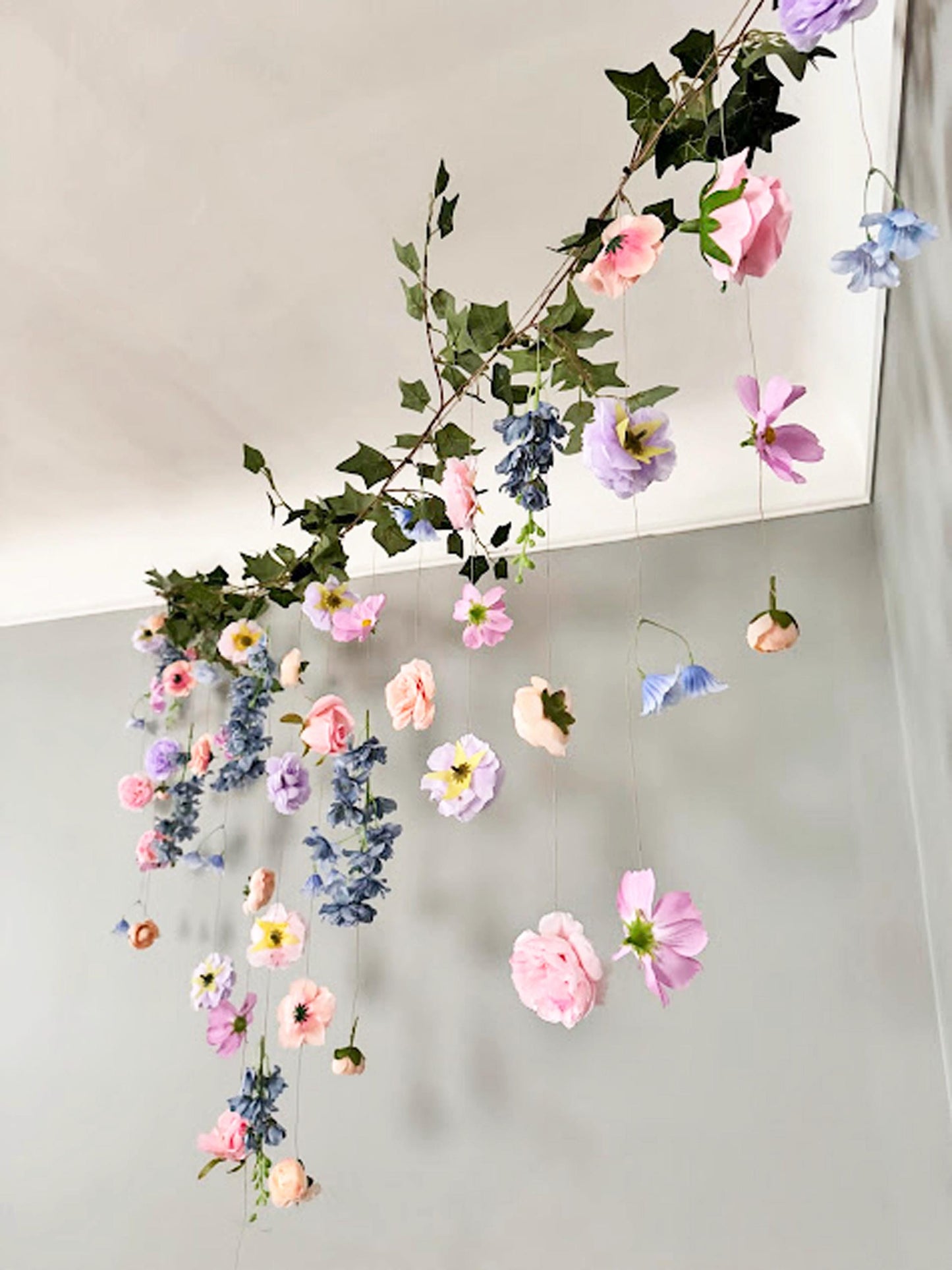 Decorative floral arrangement hanging against a neutral background