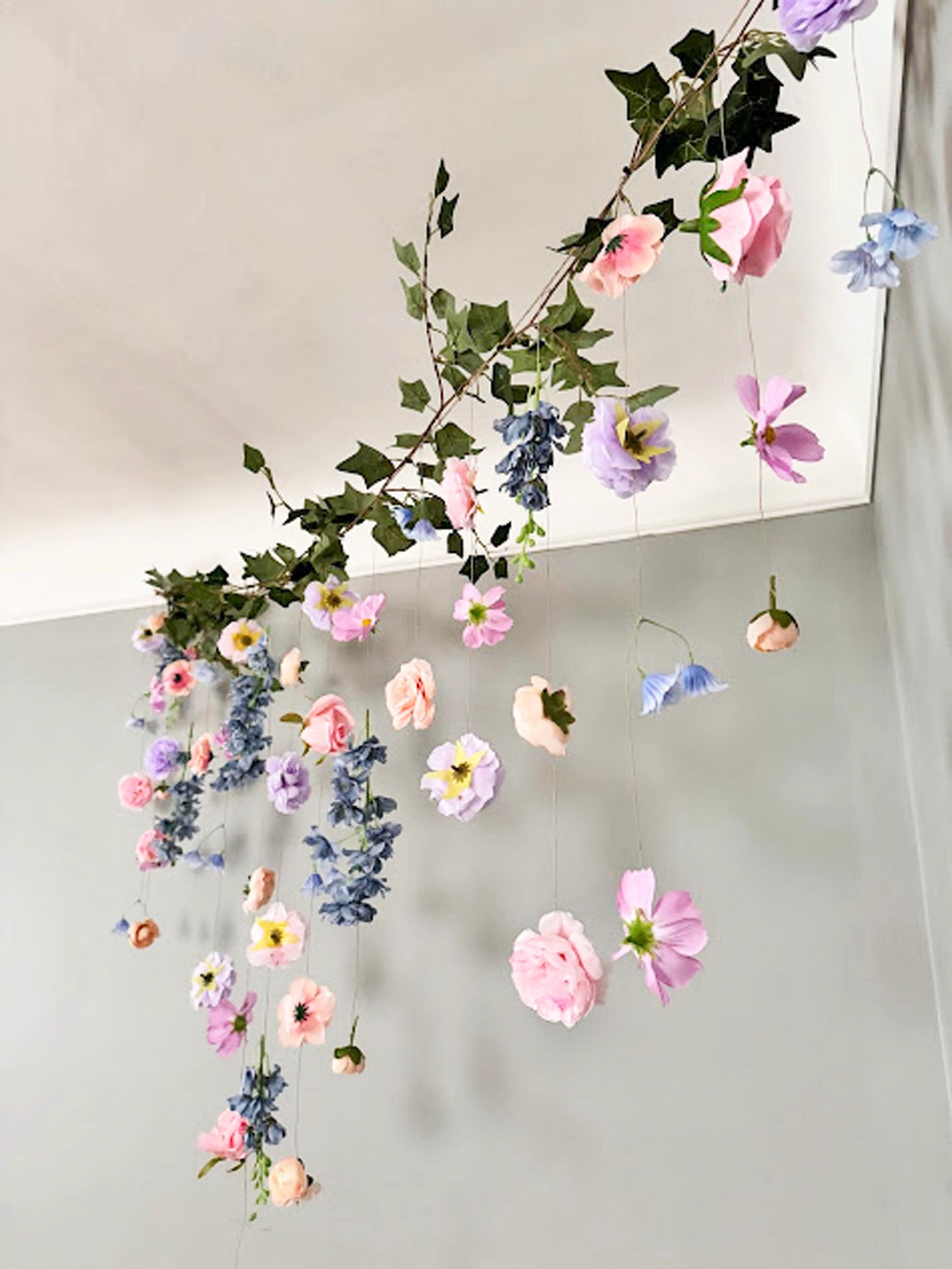 Decorative floral arrangement hanging against a neutral background