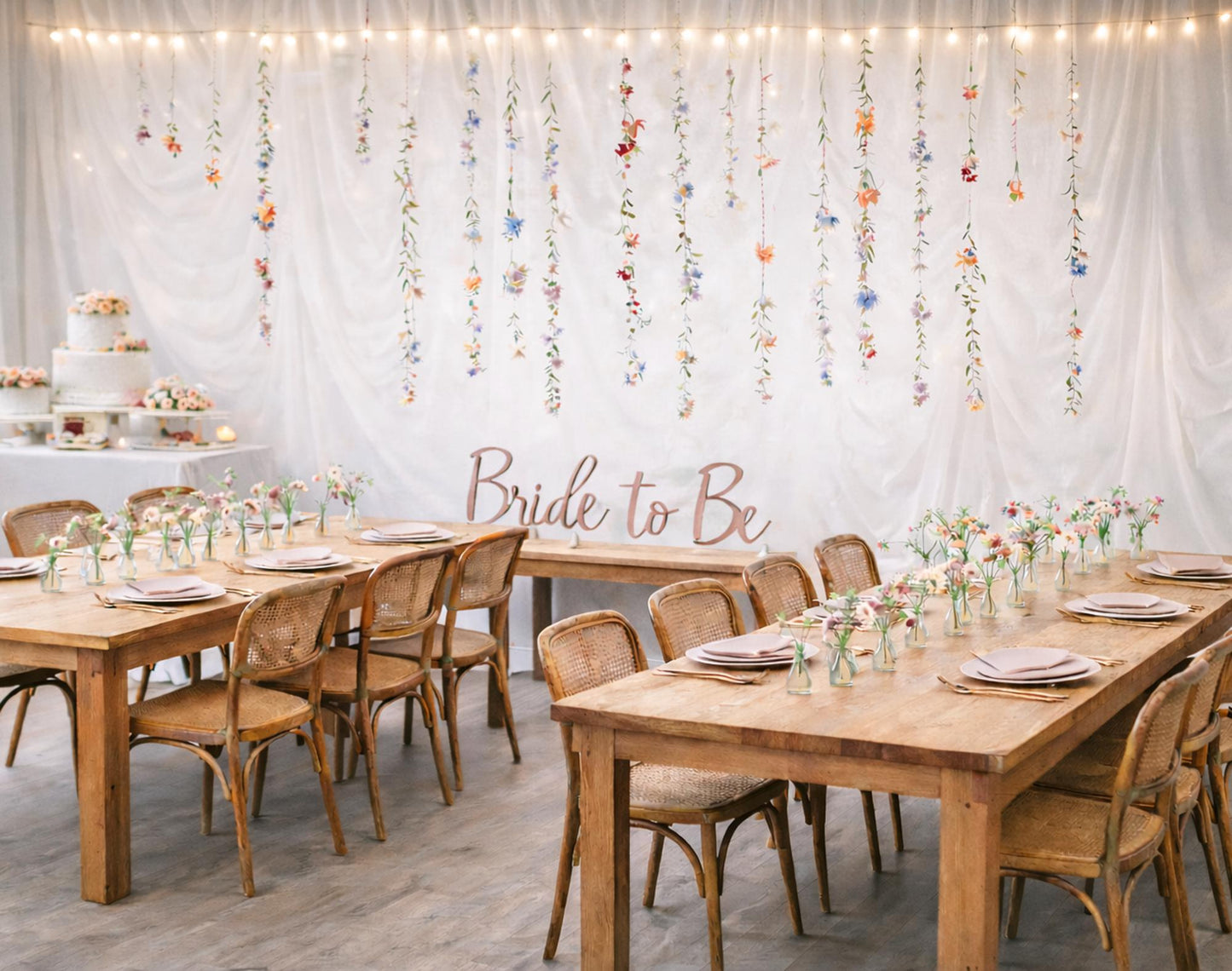 Dining room setup with wooden tables, chairs, and floral decorations on the wall.