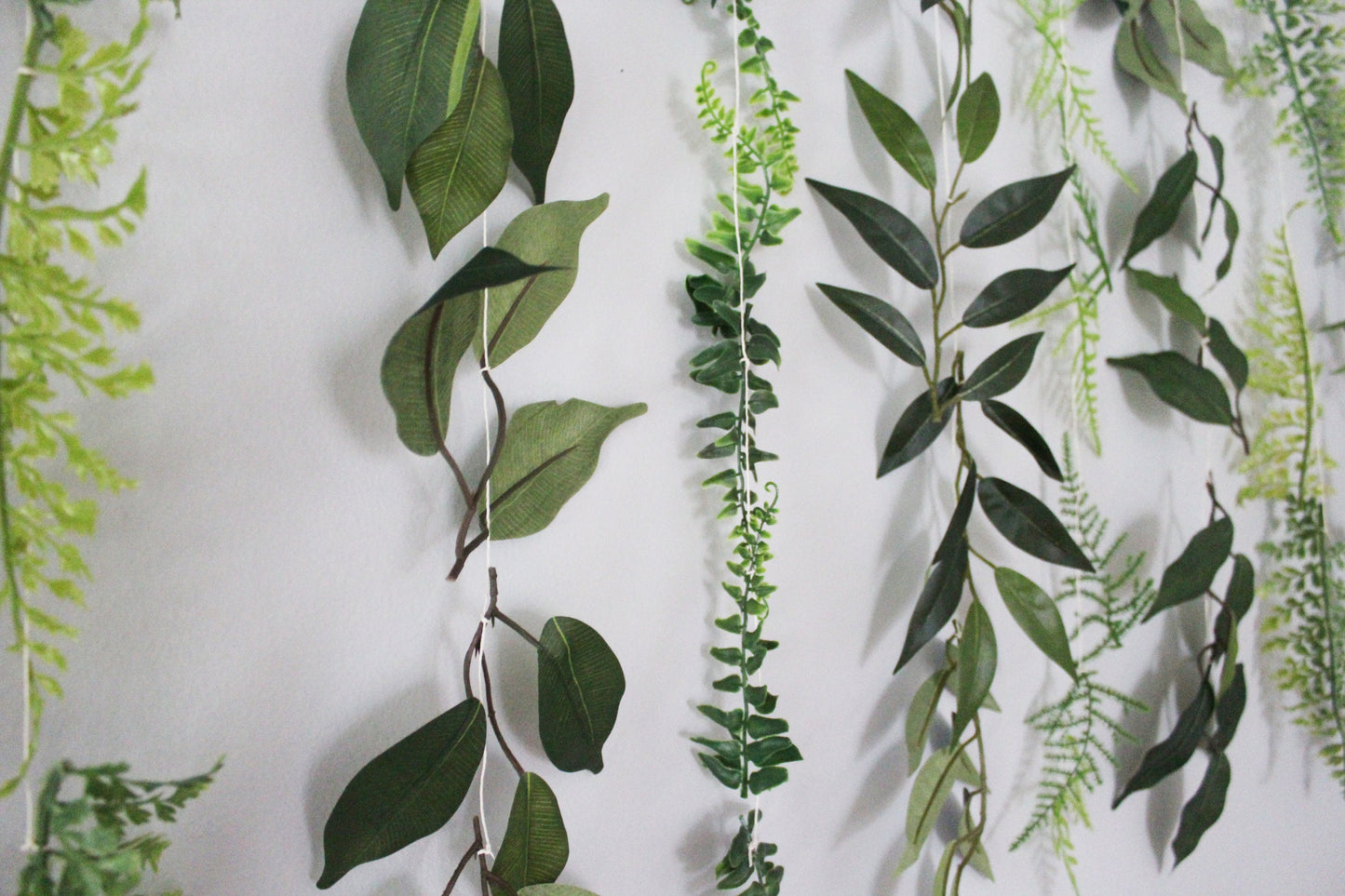 Artificial green leaf garlands on a white background