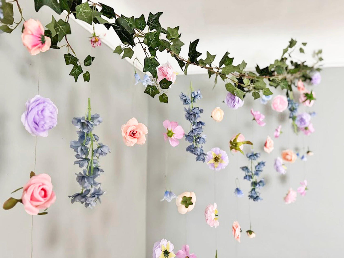 Decorative floral arch with pink, purple, and blue flowers on a plain background