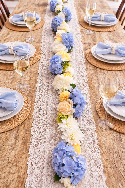 Elegant table setting with a floral runner and wine glasses.