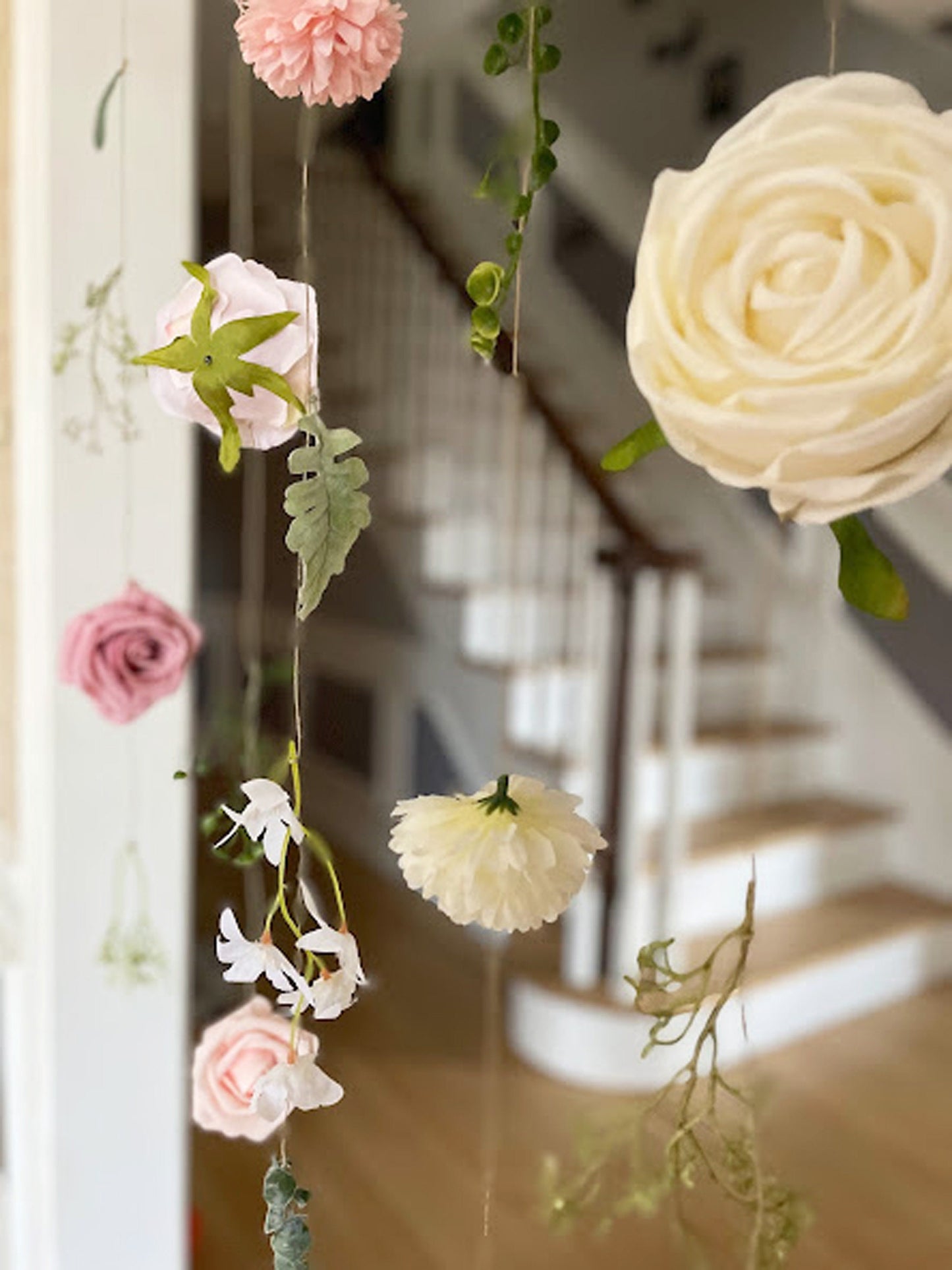 Decorative floral garland with flowers and greenery hanging indoors.