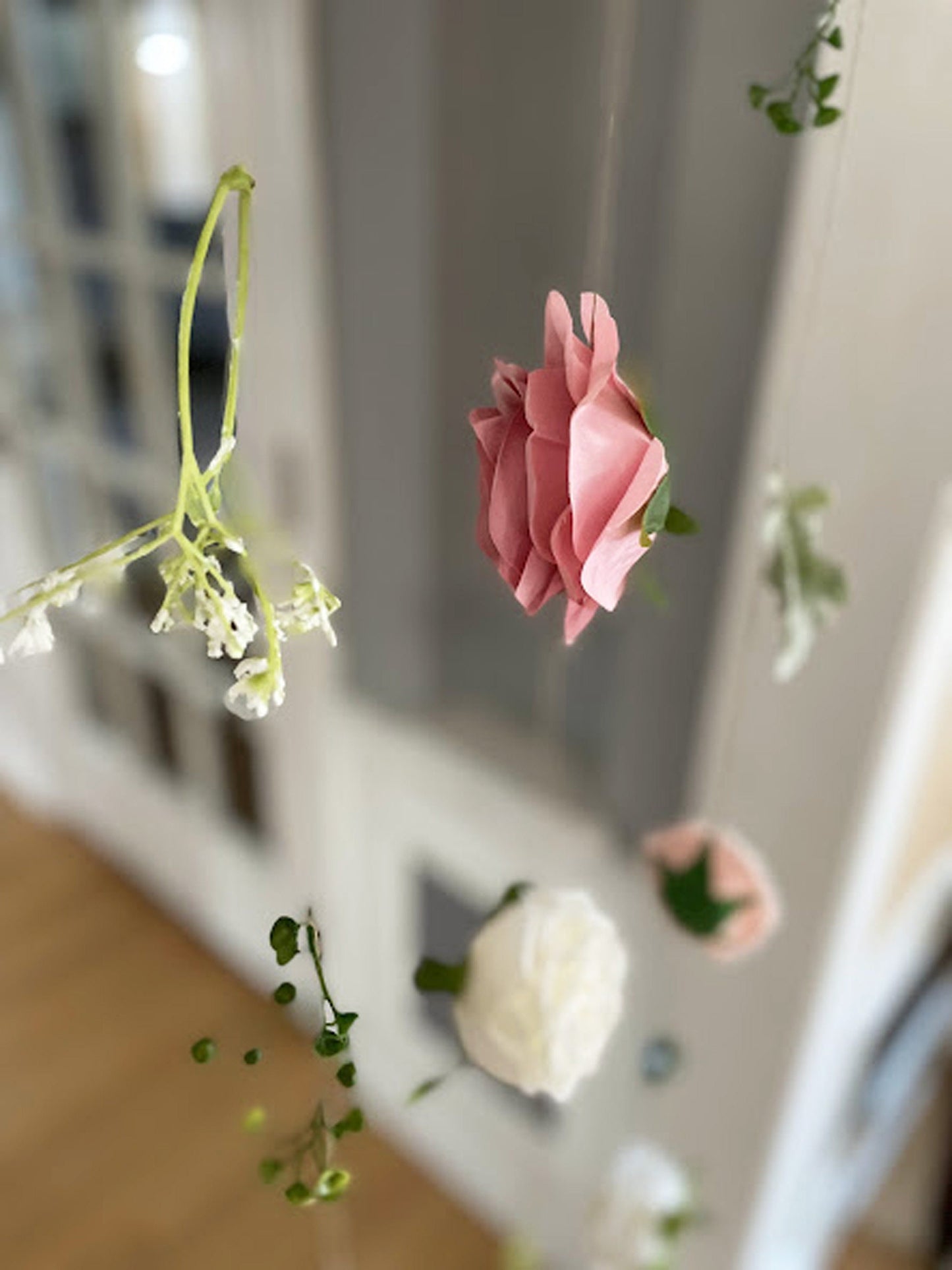 Pink artificial flower hanging indoors with a blurred background